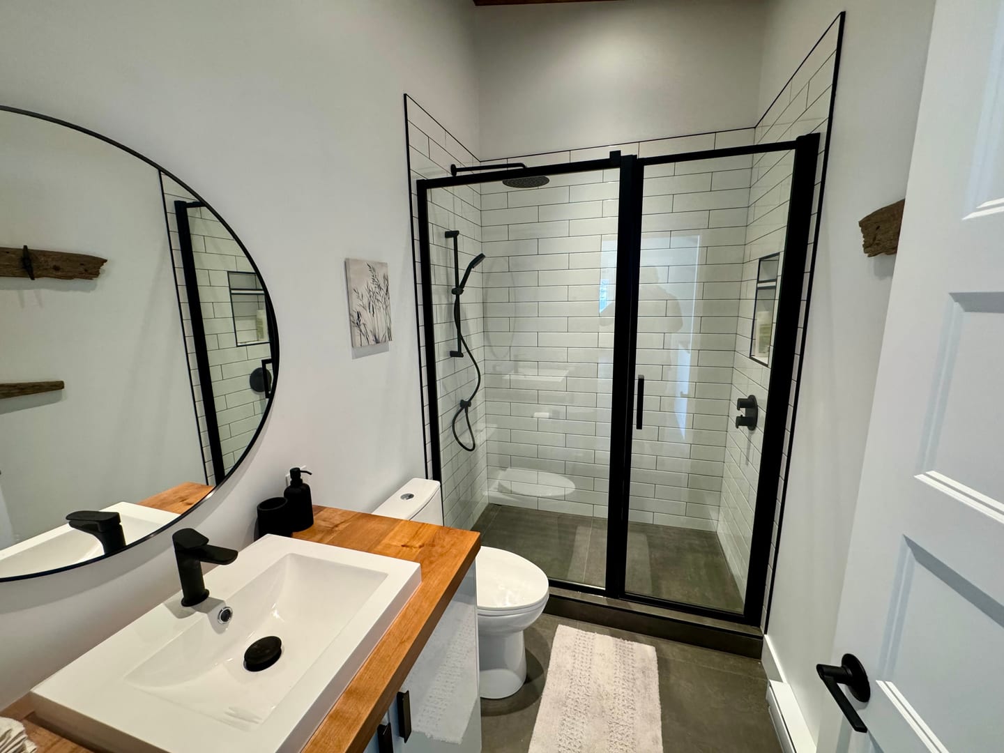 Salle de bain avec douche italienne, tuiles subway et vanité bois