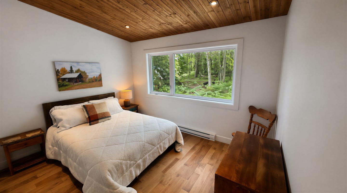 Chambre d’invité avec lit Queen et fenêtre sur la forêt