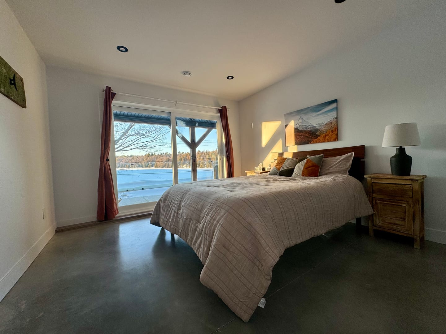 Chambre principale avec lit King et grande fenêtre sur le lac